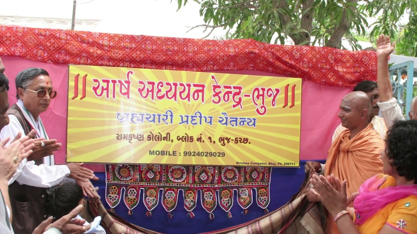 Swami ji at the founding/inauguration ceremony of Aarsh Adhyayan Kendra, Bhuj, beside the nameplate banner