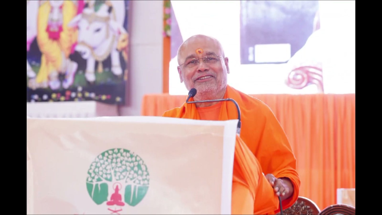 Swami ji speaking at a podium