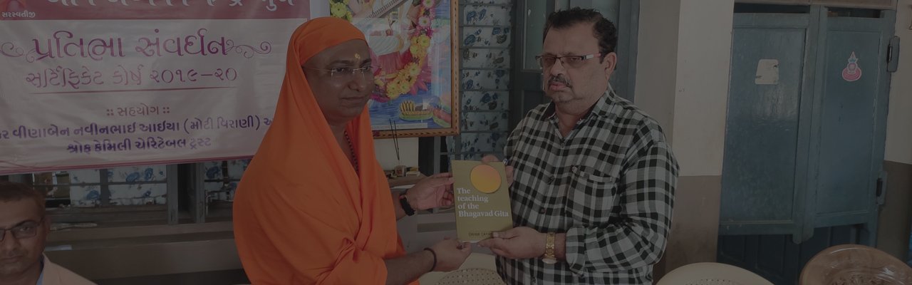 Swami Pradeeptananda Saraswati gifting a Gita commentary book at a PSCC event